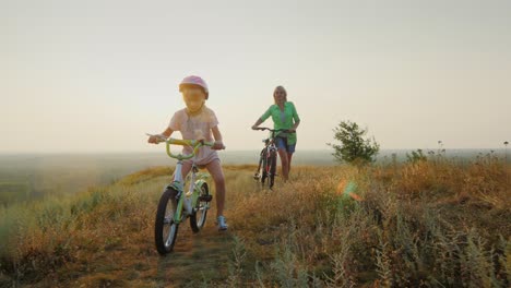 a woman with a child rides a bicycle in nature 1