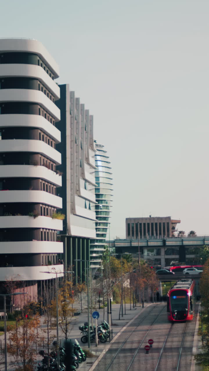 Nice, France - November 4, 2024: Red tram moving through the city near the Sheraton Nice International Airport Hotel. Vertical