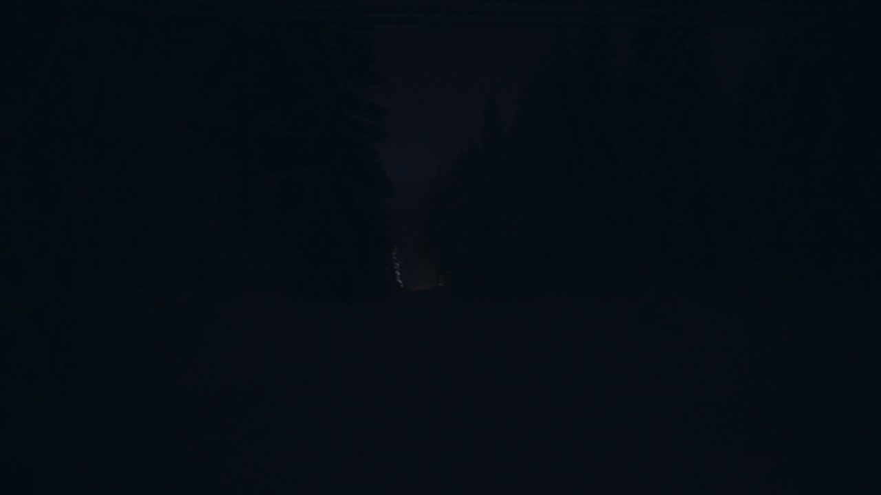 vista trasera lejana de la conducción de automóviles en la oscuridad en una fría noche de invierno