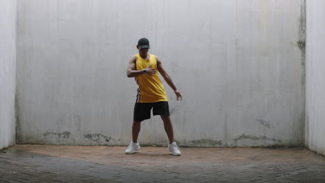 dancing man young happy street dancer performing various freestyle dance moves fit mixed race male practicing in grungy warehouse wearing yellow vest