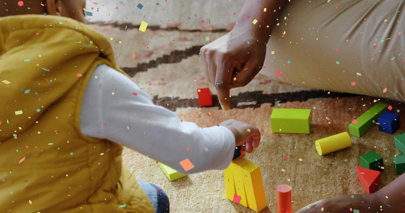 Dad reaching blocks, guiding child stacking for education on rug, confetti overlay noting progress