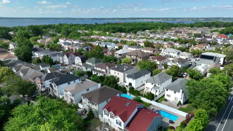 tomada aérea amplia que muestra casas estadounidenses hermosas y caras con piscina y bahía en el fondo - toma de avión no tripulado del suburbio de la ciudad de nueva york