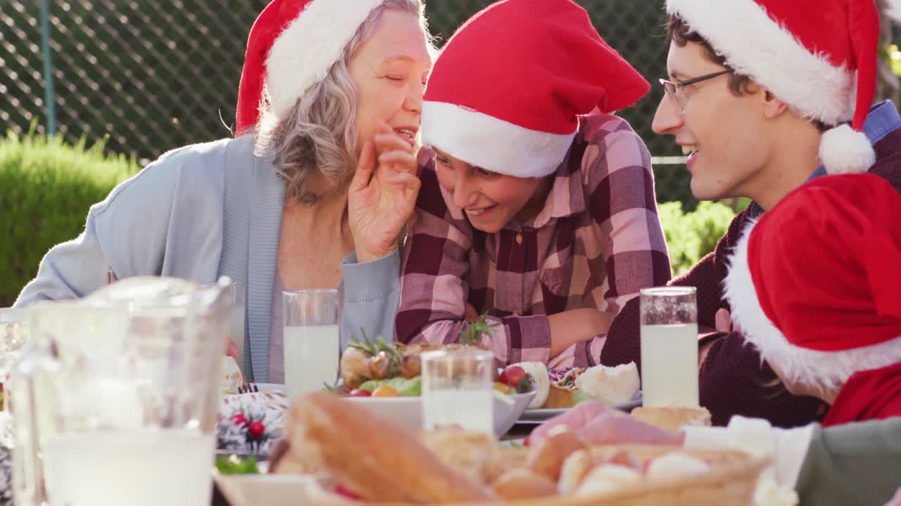 feliz familia caucásica teniendo la cena de navidad en el jardín