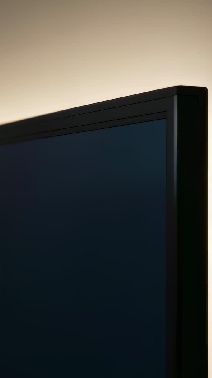 Video verticale: La telecamera esegue un panning rivelando un display a schermo piatto vicino a una parete per mostrare la cornice superiore e l'alone.
