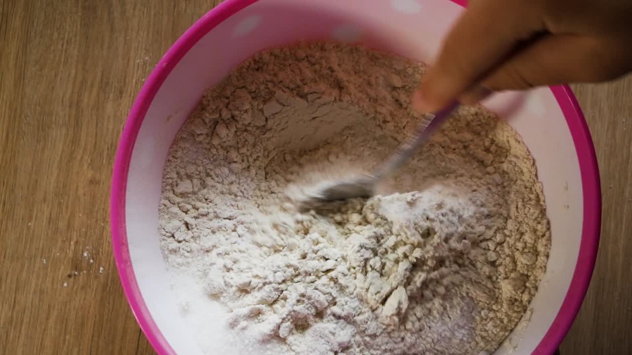 Mixing flour and sugar for pancakes preparation in home kitchen. Amateur cook. Top mid range view.