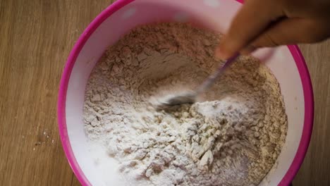 mixing flour and sugar for pancakes preparation in home kitchen. amateur cook. top mid range view.
