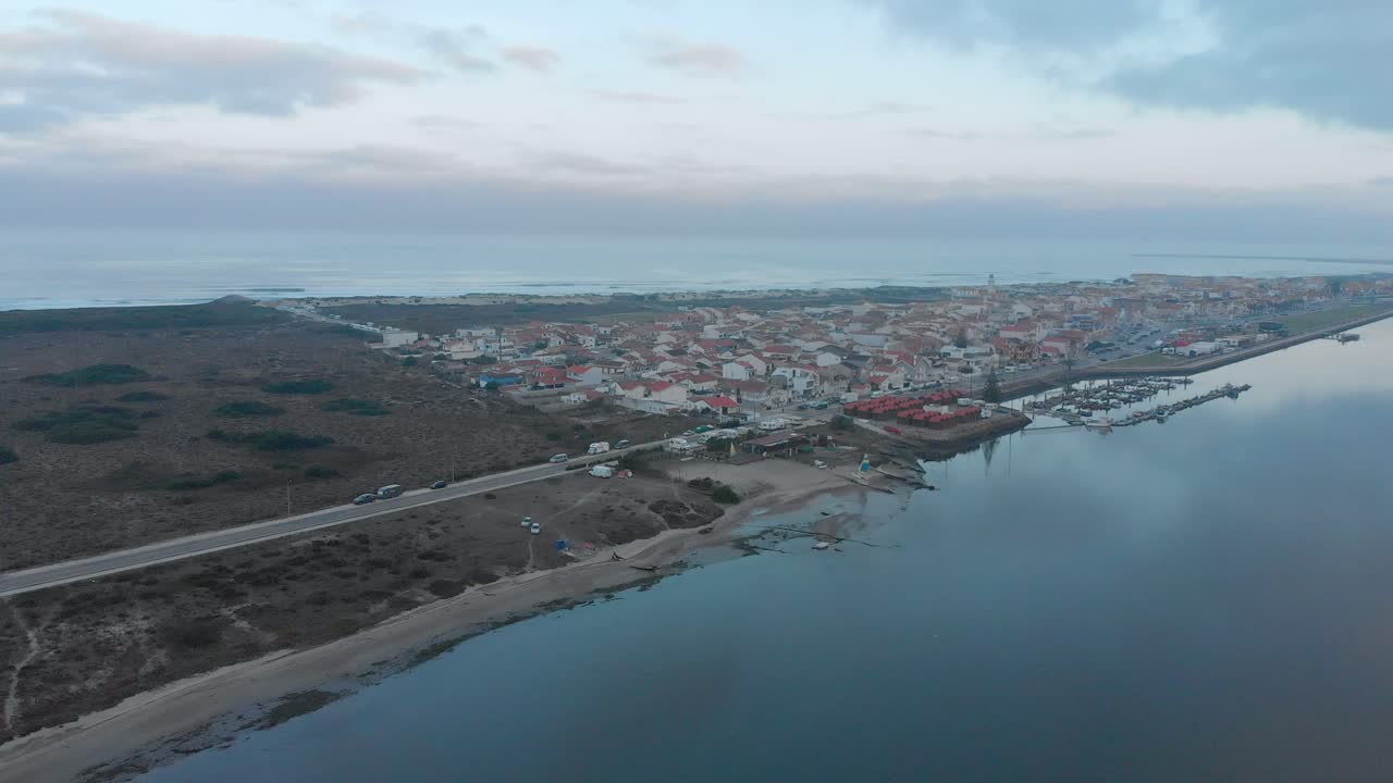 vista aérea de un pequeño pueblo entre el océano y el río en un día nublado