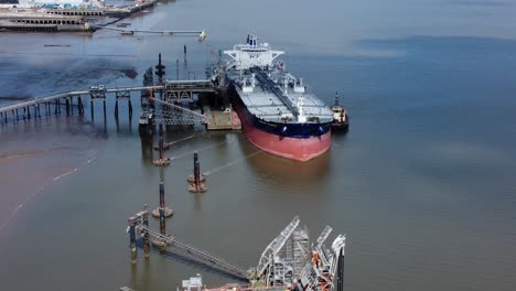 crude oil tanker ship loading at refinery harbour terminal aerial view reverse above platform