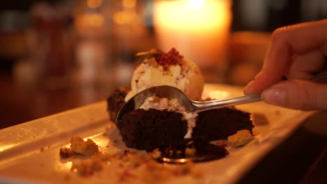 Slowmo---Schöne-Blonde-Frau,-Die-Schokoladenbrownie-Mit-Eiscreme-Im-Luxusrestaurant-Isst