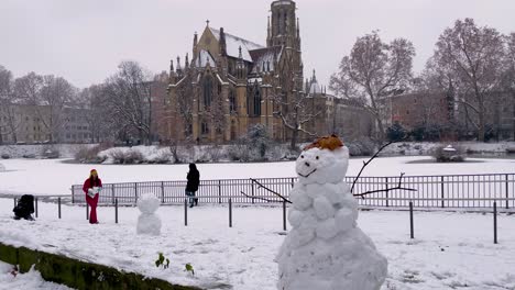 johanneskirche at feuersee covered in snow and snowman smiling during winter in stuttgart, germany.