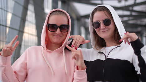 two women in hoodies and sunglasses