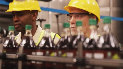 workers checking bottles on production line