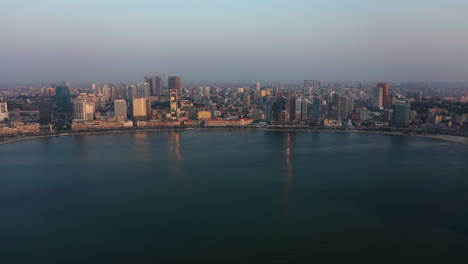 fast traveling front, sky line luanda city, golden hour flying over luanda bay, africa