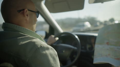 Hombre-Conduciendo-Un-Coche-Y-Mirando-El-Mapa