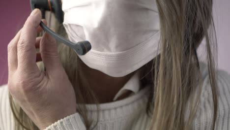 Mujer-Con-Auriculares-Ajustando-La-Máscara-Facial-Primer-Plano