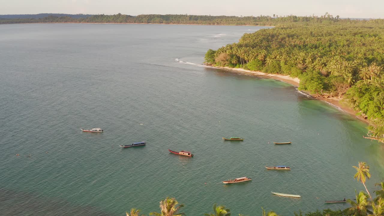 Aerial flight above anchored fishing boats in secluded Indonesian island bay