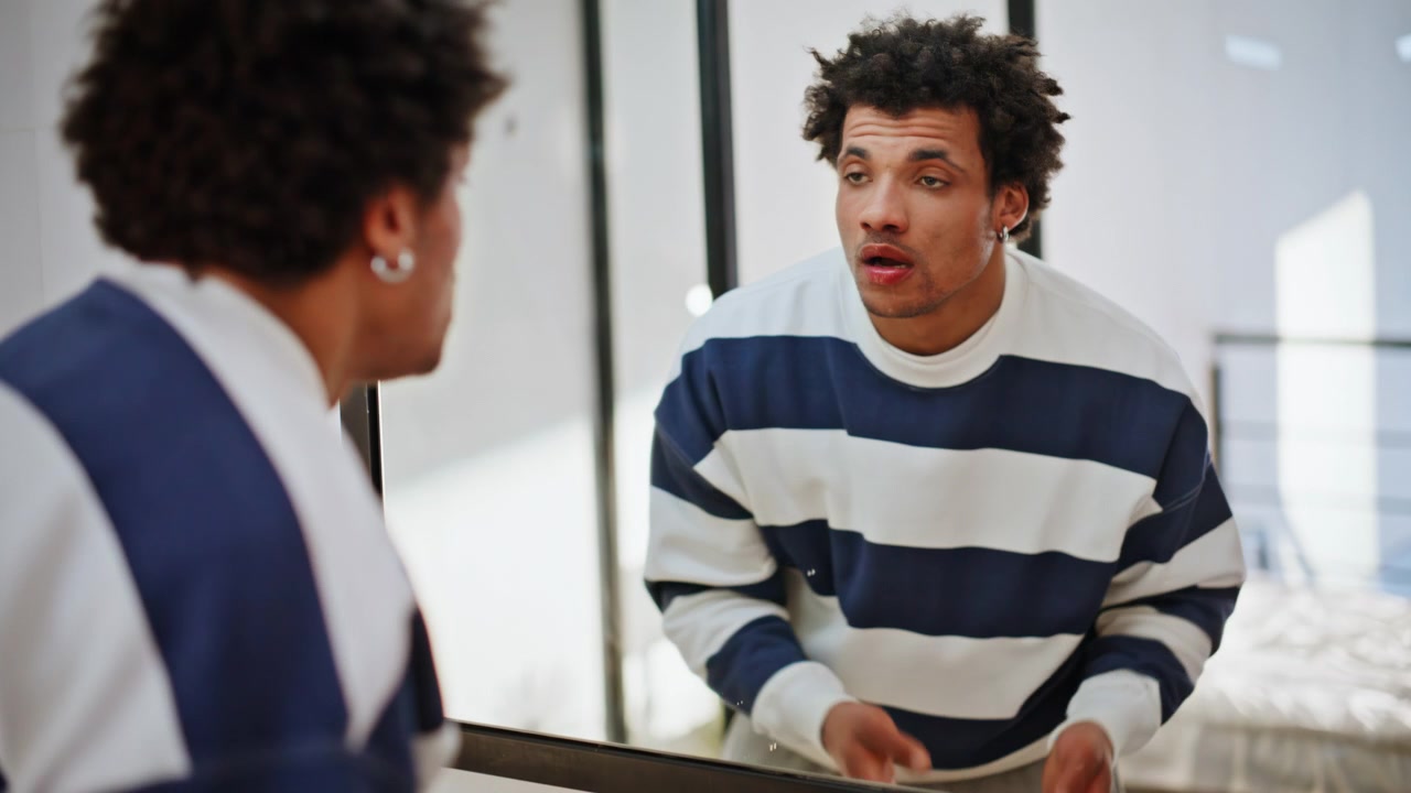 Tired man cleaning face looking mirror closeup. African american guy hygiene