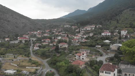 aerial top view of greek village traditional lifestyle agriculture style local houses and road mountains around greece epirus
