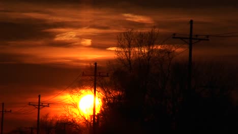 A-Colorful-Sunset-With-Powerlines-And-Silhouetted-Trees