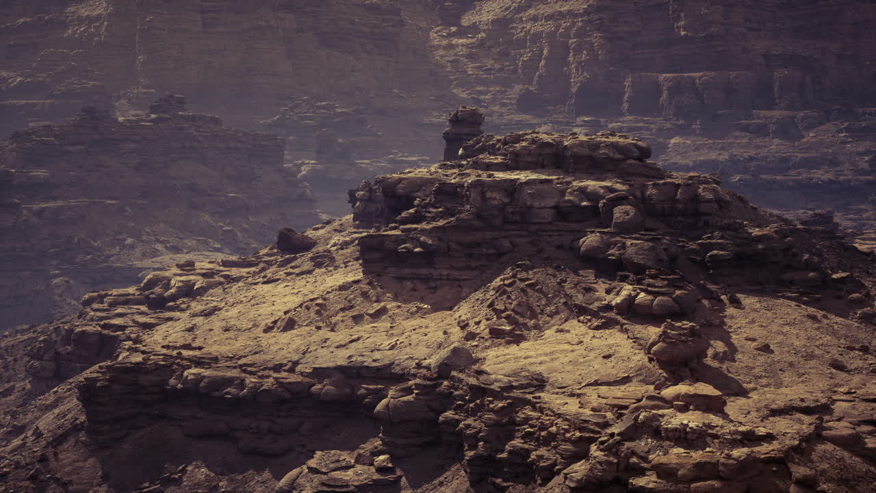 Rock formations and rugged terrain in a dry desert landscape at dusk