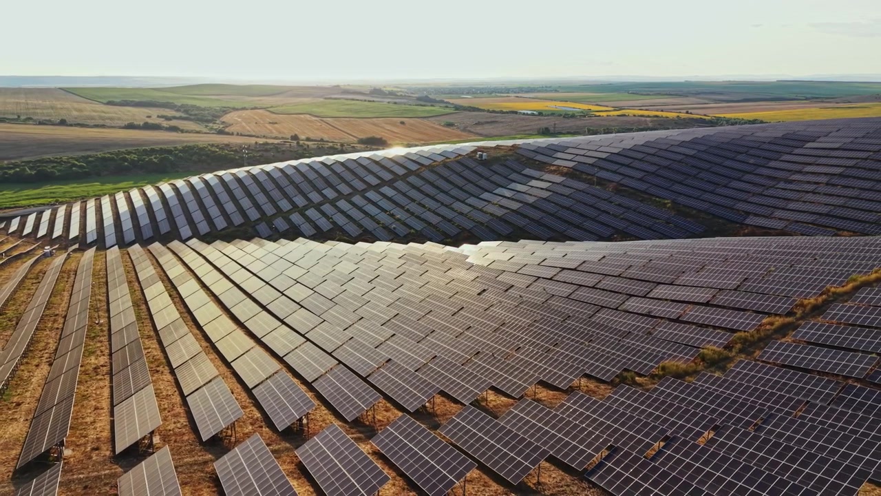 Solpaneler dækker et stort område på en solskinsdag i en vedvarende energipark, der leverer ren energi til den omkringliggende region