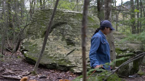 young woman takes her dog on hike through upstate new york hiking trails and dense forest