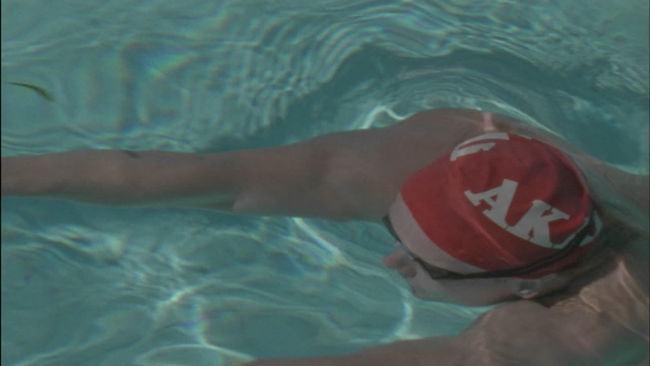 un hombre nada a través de una piscina gira y nada de regreso