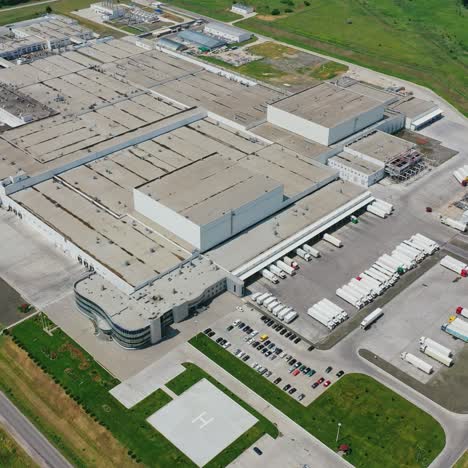 modern industrial infrastructure. huge production plant among green field. view from above on roofs of large buildings of industry. aerial view.