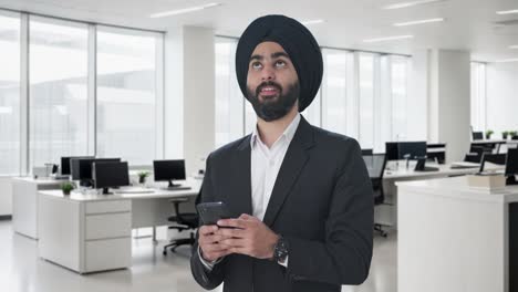 happy sikh indian businessman texting someone