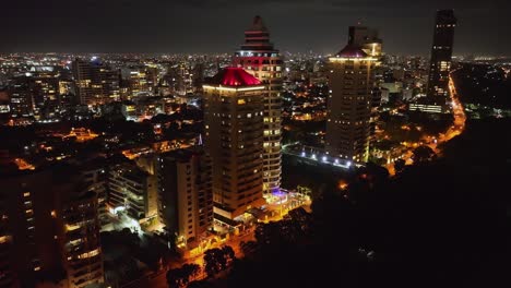 vista de drones de los edificios de la torre de iluminación y el paisaje urbano de la ciudad de santo domingo por la noche