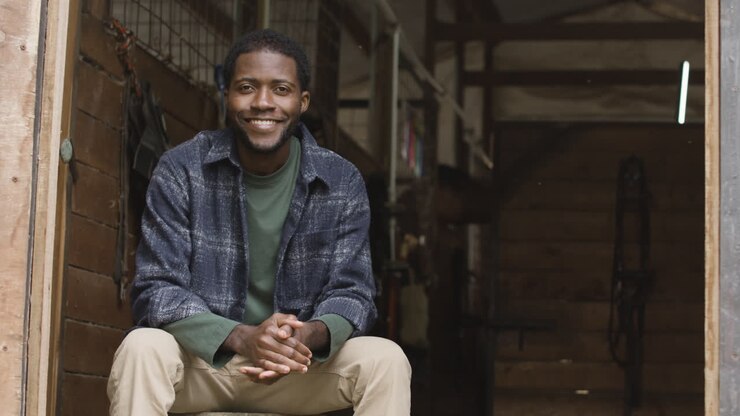 Smiling Man Sitting In A Stable