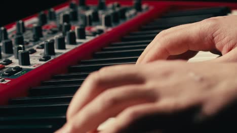 close up of keyboard player hands playing rock music with keyboard at the concert in studio, rehearsal room, macro play on synthesizer.