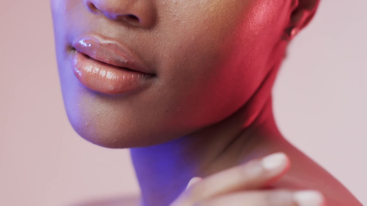 labios de una mujer afroamericana en luz azul y rosa, cámara lenta