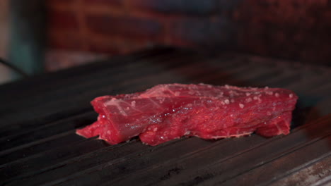 poner bistec en la parrilla carne cruda