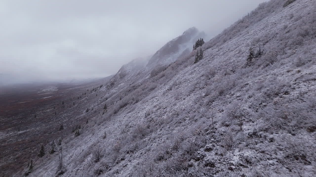 Snowy Ogilvie Mountain Range Against Overcast Sky In The Yukon Territory Of Northwestern Canada. Aerial Drone Shot