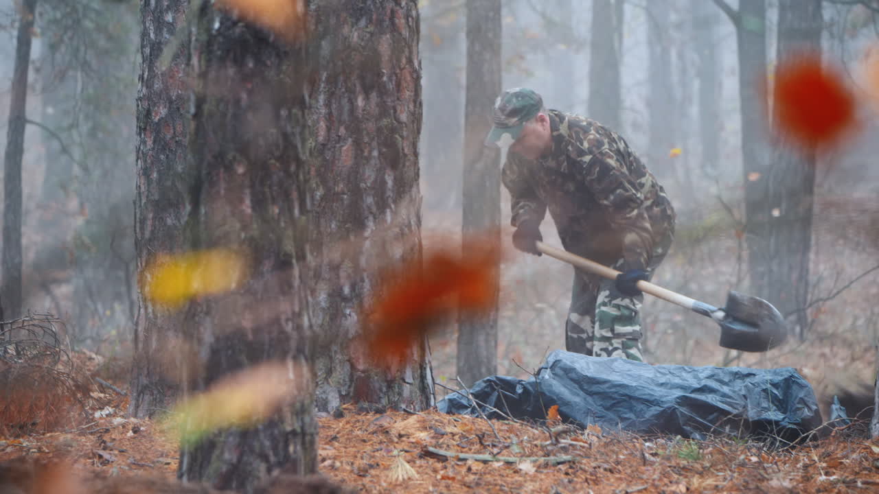 un criminal excava el cuerpo de su víctima en el bosque