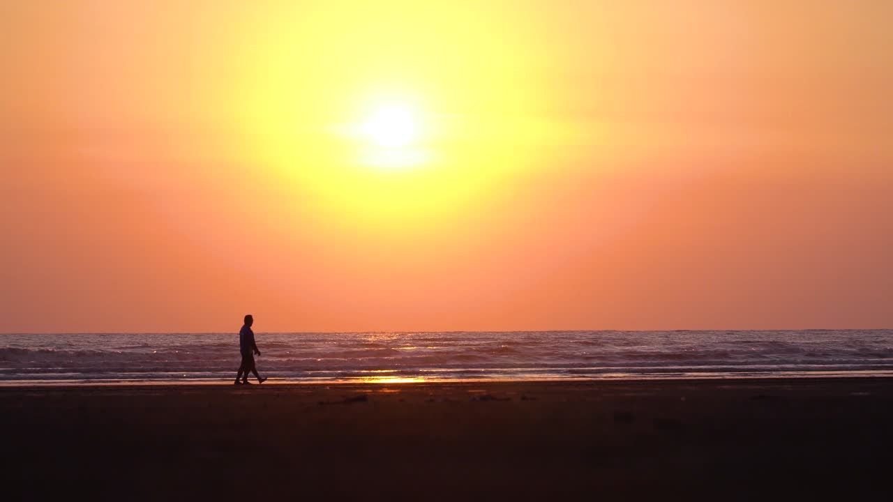 привлекательный вид на золотой час над морем, люди гуляют по пляжу