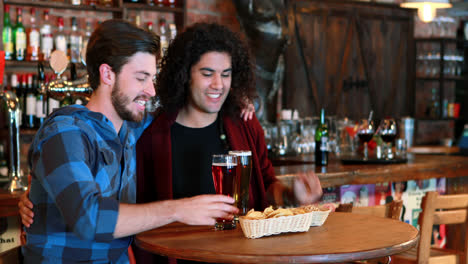 amigos aplaudiendo mientras beben cerveza.