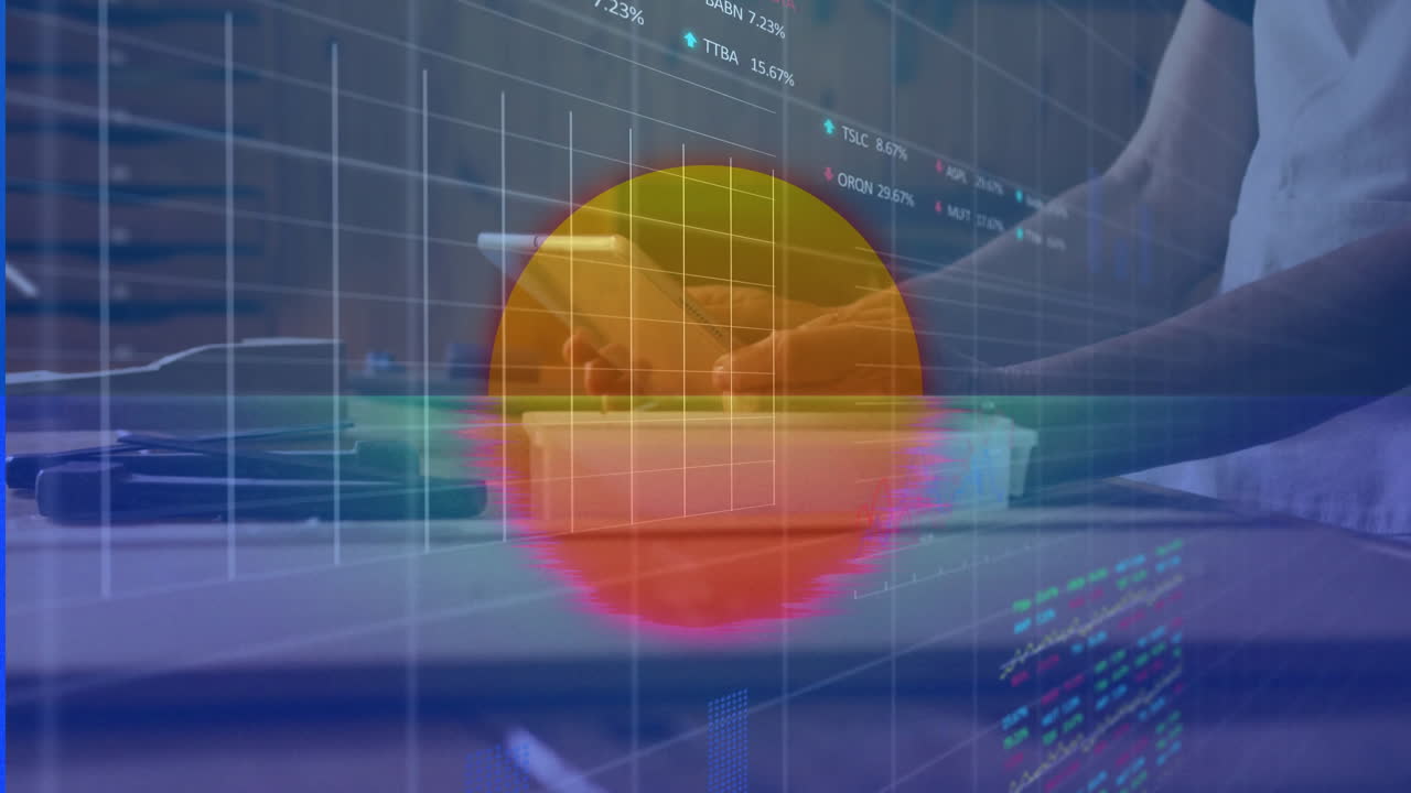 Man's hands using stylus writing on digital tablet while financial charts floating over wooden desk