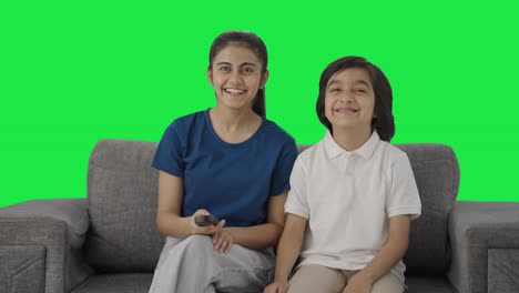 hermanos indios viendo la televisión en casa felizmente pantalla verde