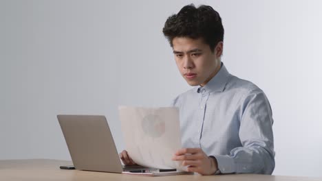 문서와 노트북으로 일하는 사업가