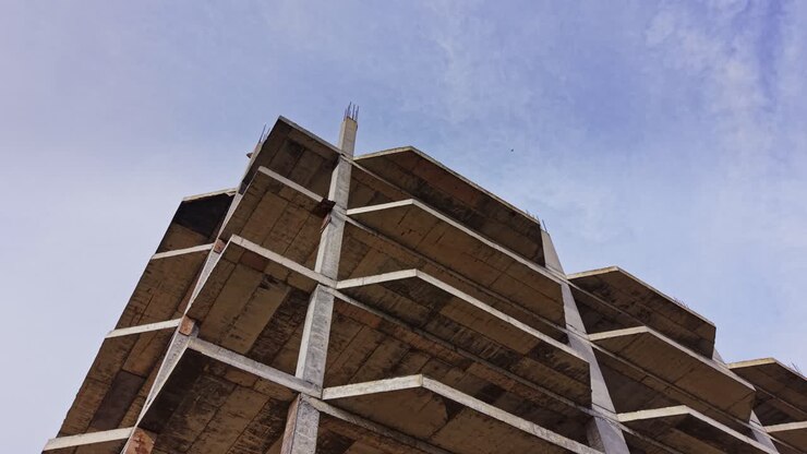 Luftaufnahme von einem unfertigen Betongebäude unter blauem Himmel