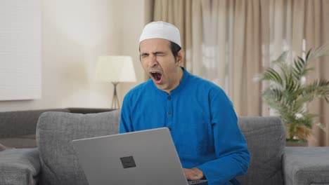 tired muslim man using laptop