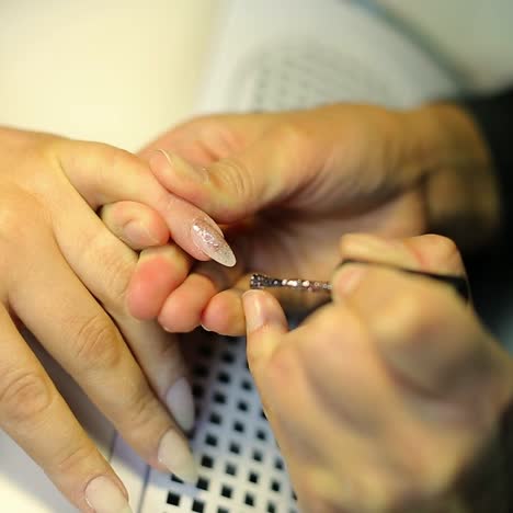 una mujer haciendo una manicura de uñas.