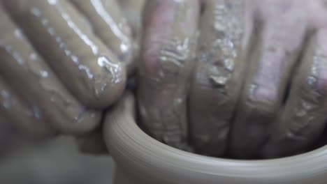 cerca de las manos de un alfarero mientras crea un frasco de arcilla, concepto de producción de cerámica. imágenes de stock. las manos masculinas del escultor en el taller haciendo un jarrón o frasco.