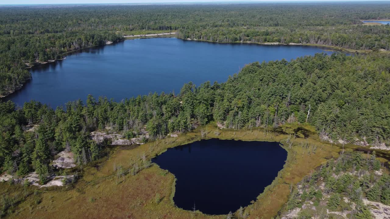 Aerial: pristine lakes amidst dense forest, Killarney Park, Canada