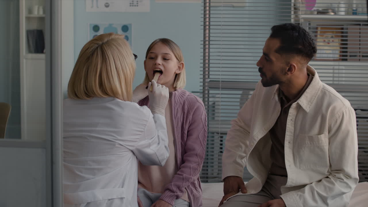 Doctor examining a child with her father present