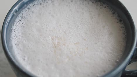 a cup of frothy coffee drink with sugar