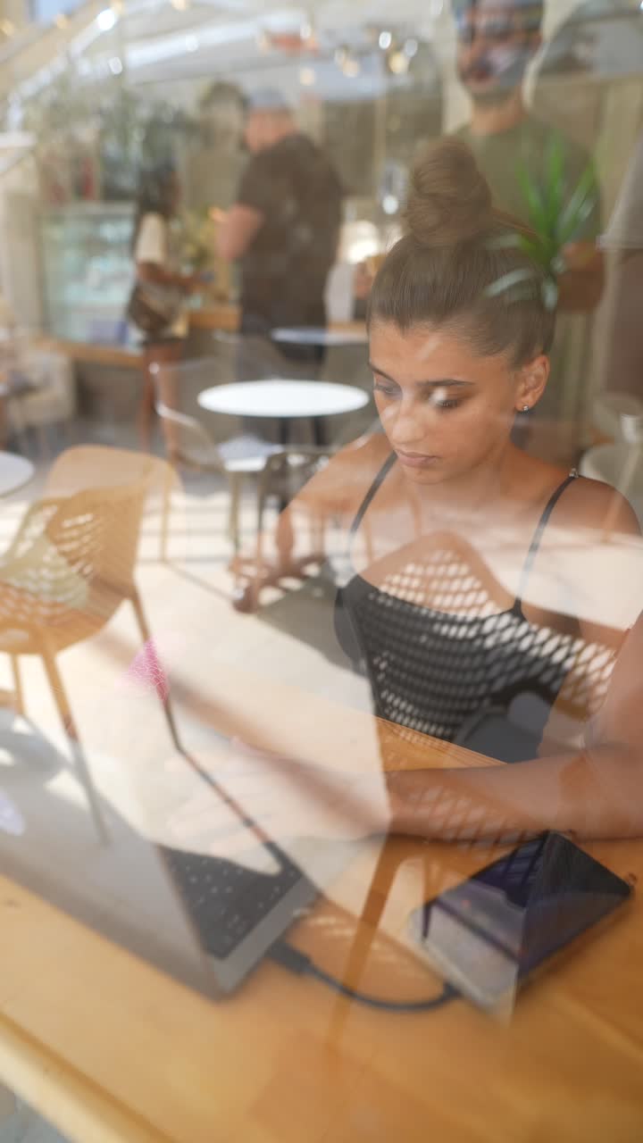 mujer trabajando en una computadora portátil en un café