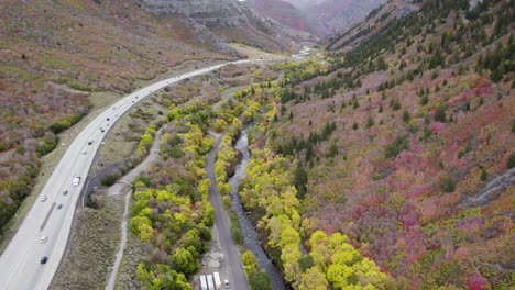 carretera en medio de montañas al lado del río, tiro aéreo de drones revela el valle y el horizonte